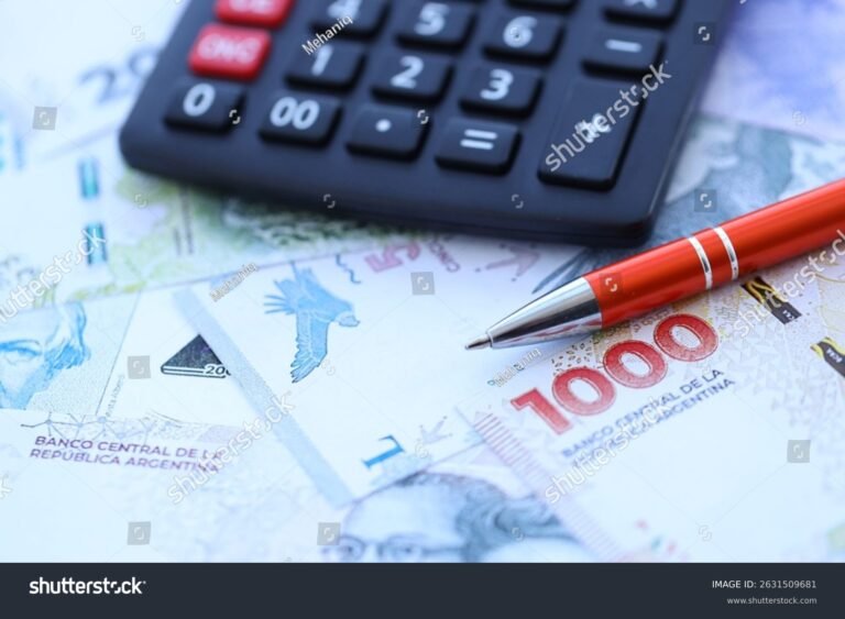 calculadora sobre mesa con billetes argentinos